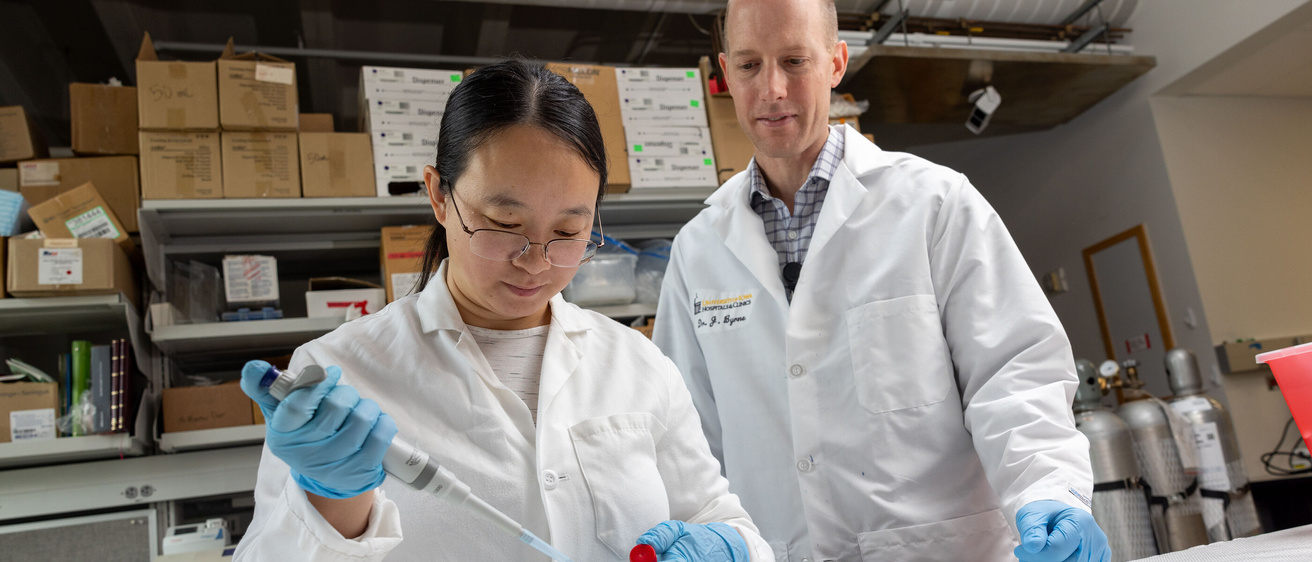 Jianling Bi, PhdD, post doctoral research scholar in the Byrne lab, with James Byrne, MD, PhD, in his lab at the University of Iowa’s Carver Biomedical Research Building on Thursday, Aug. 8, 2024. Byrne studies the use of molecular gastronomical techniques to create novel materials for the treatment for cancer, including the gas-entrapping foam pictured.